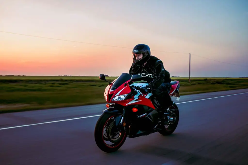 Person Riding Red Honda Motorcycle