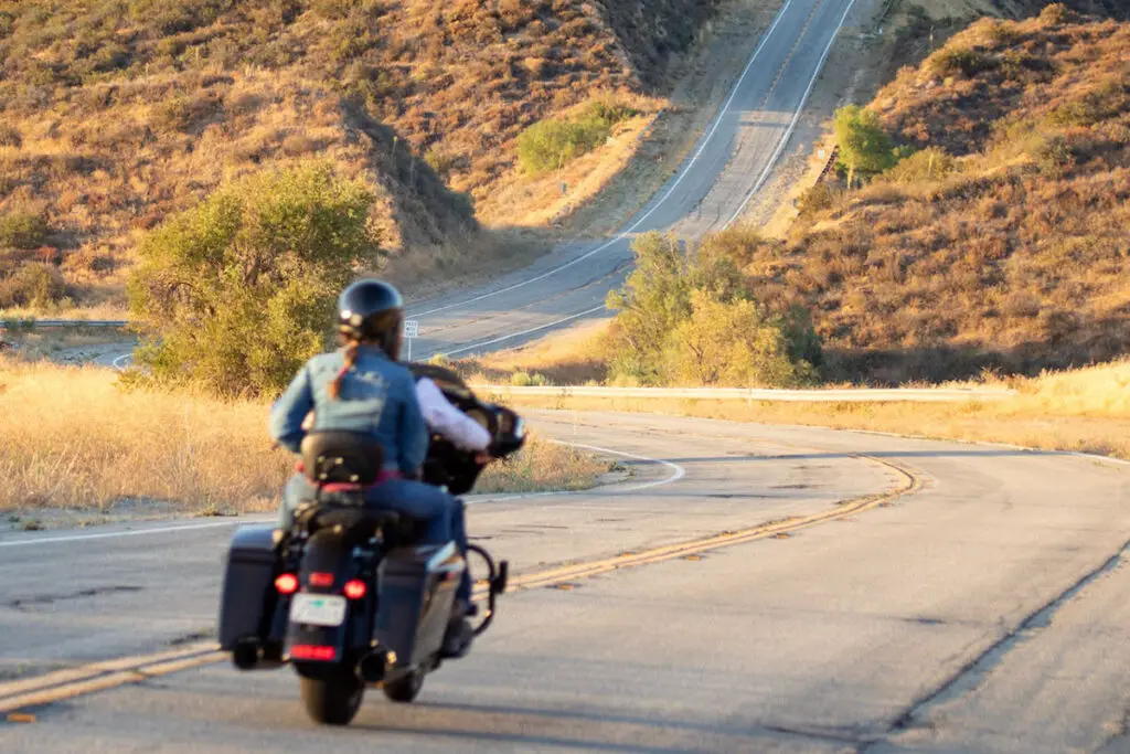 People Riding a Motorcycle on a Country Road