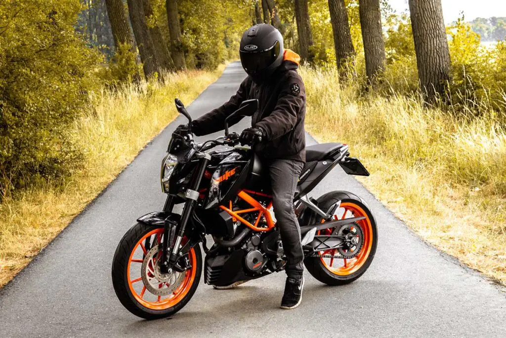 Orange and Black KTM Duke Motorcycle on Forest Road