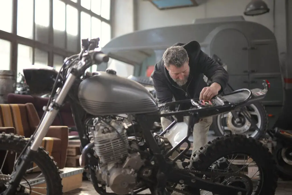 Person Working on Motorcycle in a Repair Shop
