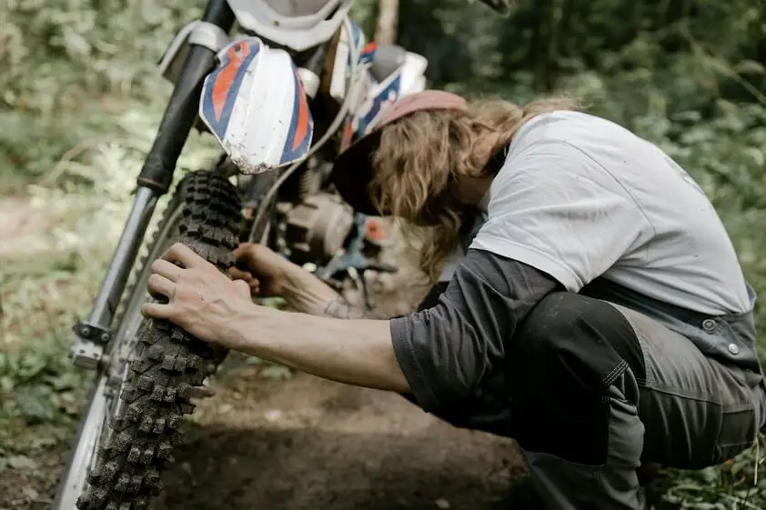 Dirt Bike Rider Checking Tire Pressure