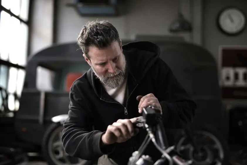 Man Working on Motorbike in Workshop